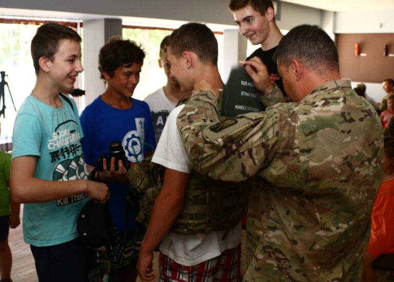 des jeunes en discussion avec un militaire