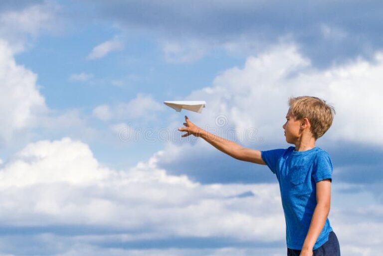 un enfant lancant un avion en papier